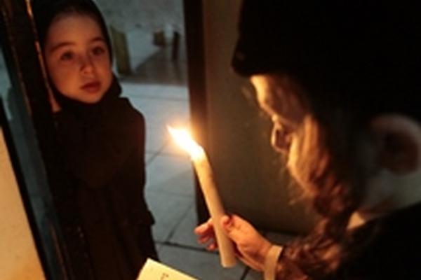 Moderhai sostiene la Torah con una mano y con la otra un cirio para prender la menorah o candelabro. Foto Prensa Libre Alvaro Interiano