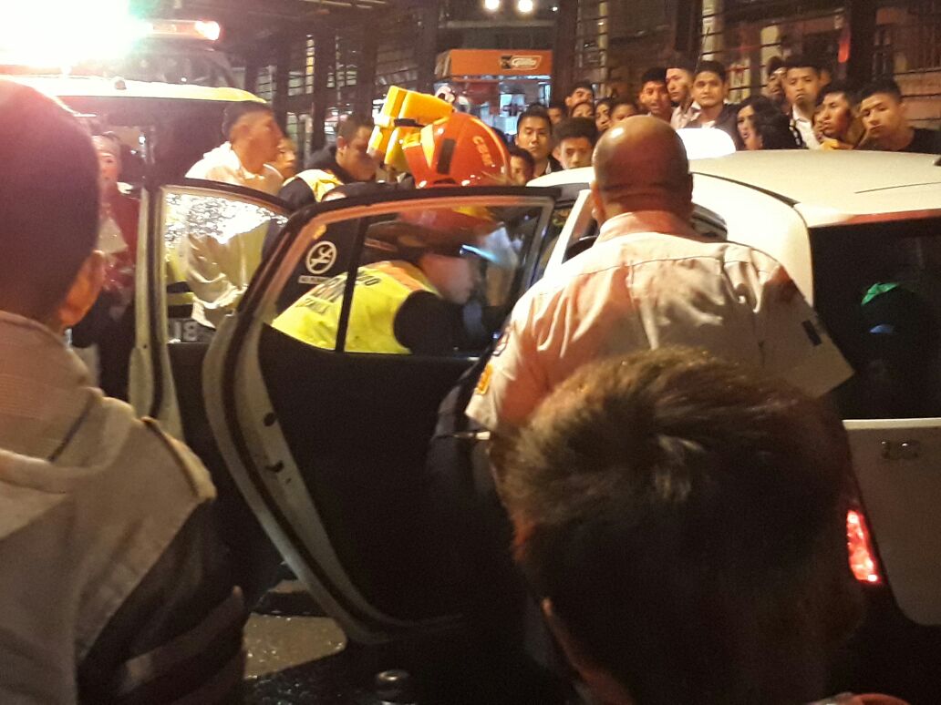 Bomberos y agentes de PMT auxilian al taxista herido en la avenida Petapa. (Foto Prensa Libre: @Villeda929).