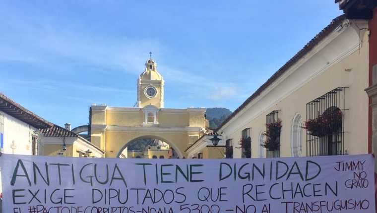La pancarta de protesta se colocó por unos minutos en la calle del Arco de Antigua Guatemala, Sacatepéquez. (Foto Prensa Libre: Julio Sicán)