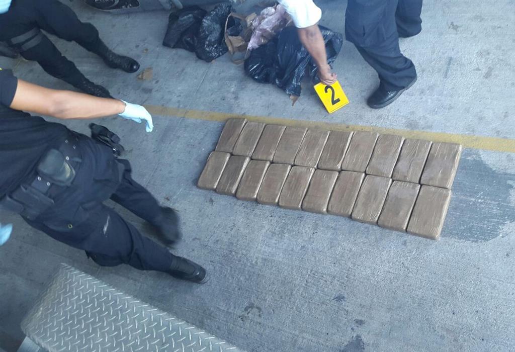 Agentes antinarcóticos revisan los paquetes encontrados dentro de una embarcación abandonada frente a las costas del pacífico. (Foto Prensa Libre:)
