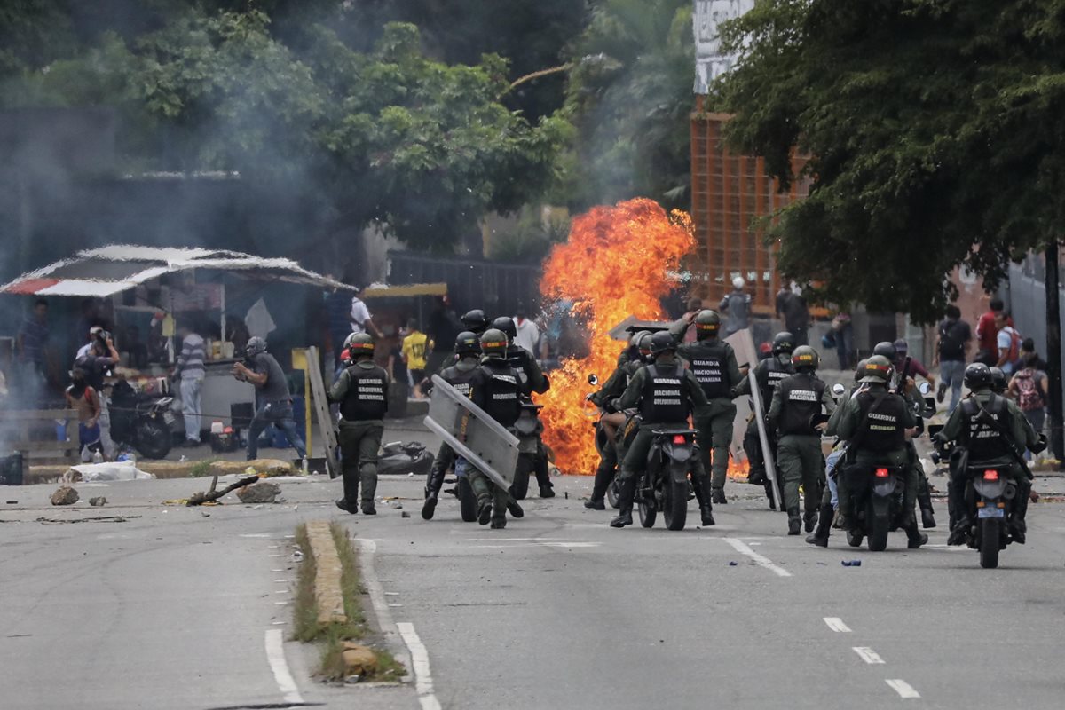Policías se enfrentan a manifestantes en Caracas. (Foto Prensa Libre: EFE)