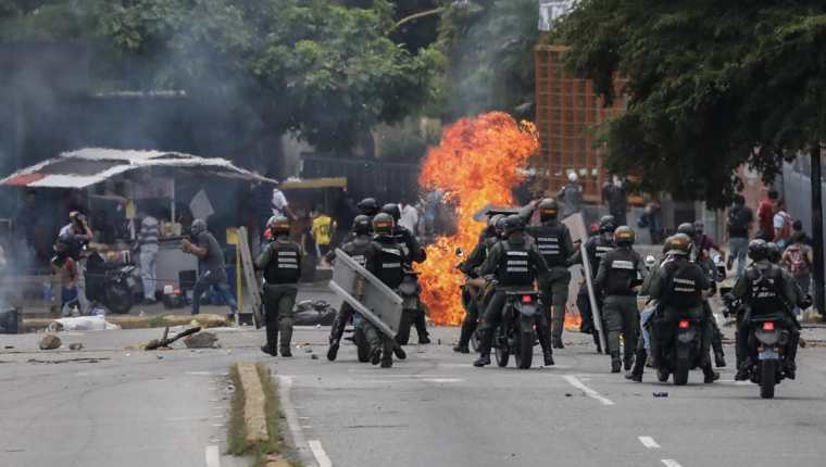 Policías se enfrentan a manifestantes en Caracas. (Foto Prensa Libre: EFE)