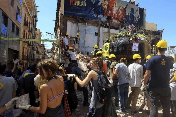 Activistas participan en la reconstrucción del edificio en Barcelona después de que el viernes último estuvieran paralizadas las obras de demolición.(Foto de Prensa Libre/EFE)
