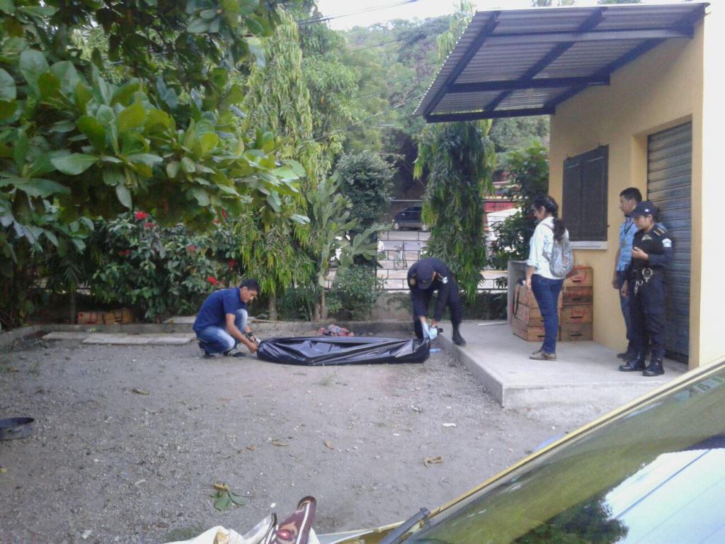 Agentes policiales cargan cadáver de hombre muerto a balazos en San José La Arada, Chiquimula. (Foto Prensa Libre: Edwin Paxtor)