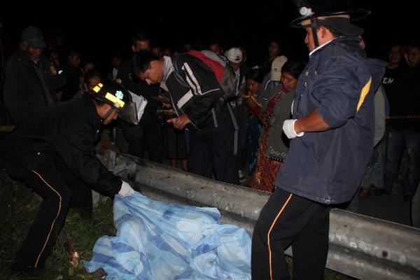 Bomberos examinan el cadáver de Crispín Tzoc Talé, quien murió atropellado en San Antonio Palopó. (Foto Prensa Libre: Ángel Julajuj).