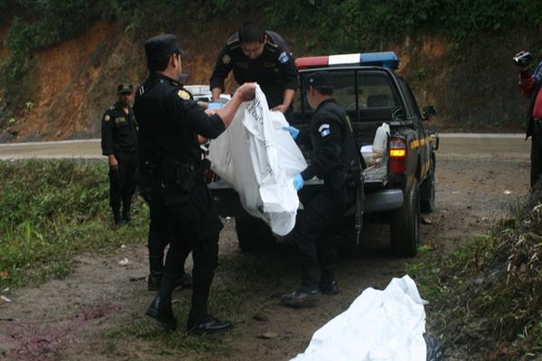 Agentes de la PNC trasladan los cadáveres de madre e hijo a la morgue de Cobán. (Foto Prensa Libre: Ángel Tax) <br _mce_bogus="1"/>