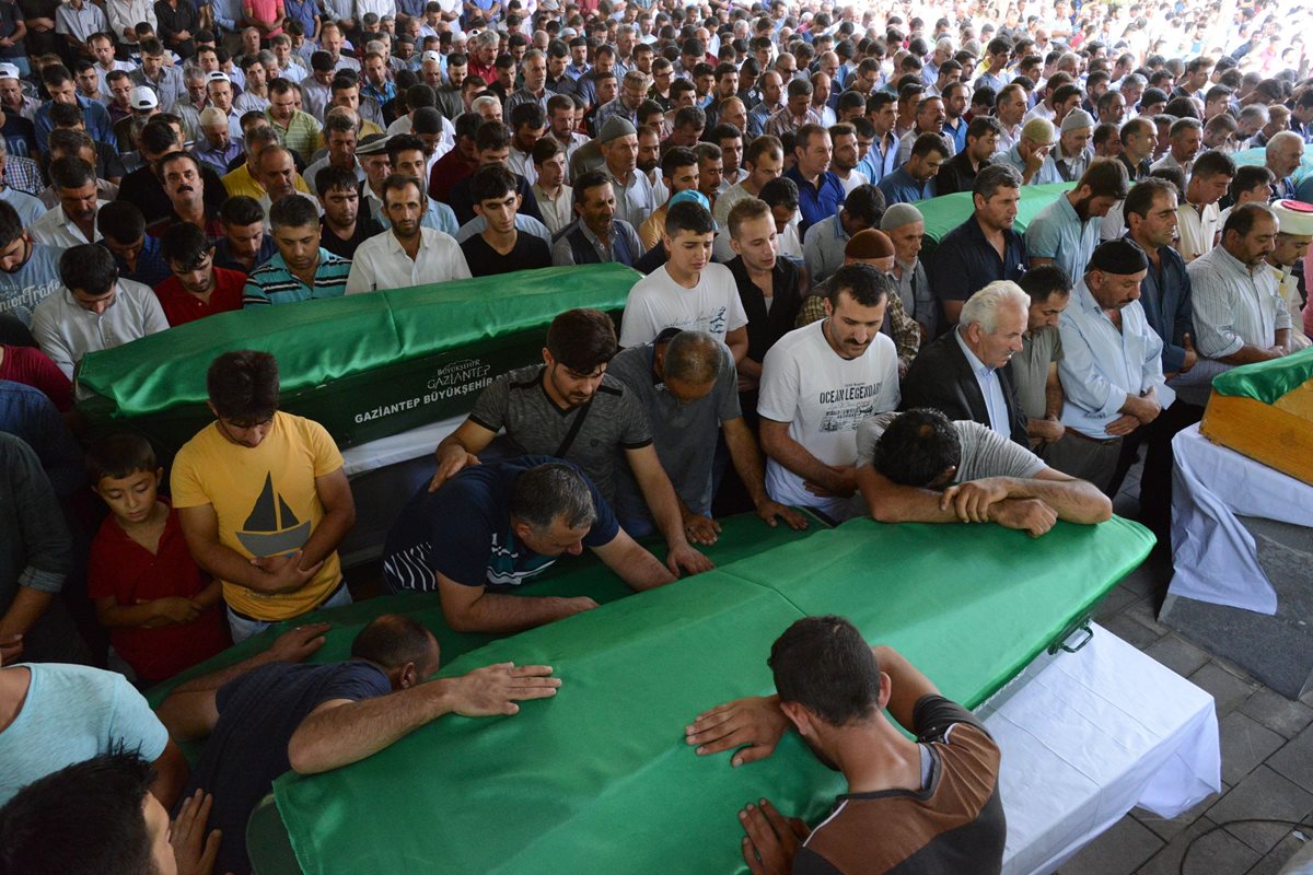 Familiares de las víctimas lloran sobre los féretros de sus seres queridos. (Foto Prensa Libre: AFP).