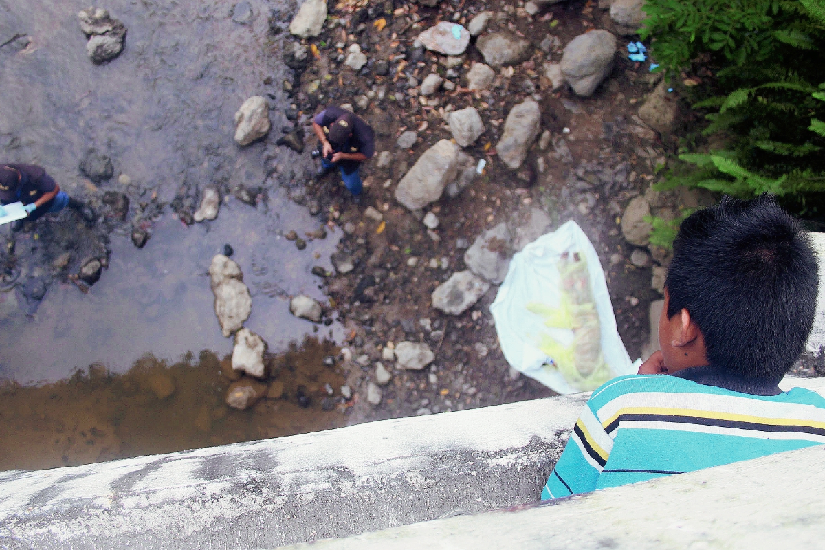 Fiscales del  MP y agentes de la PNC recaban evidencias en el lugar del hallazgo. (Foto Prensa Libre: Edwin Perdomo)