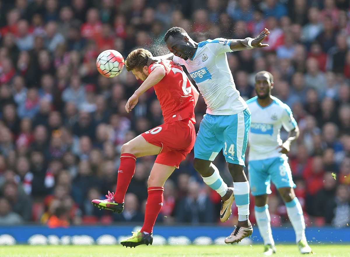 Adam Lallana (izquierda), del Liverpool, disputa el balón con Ismael Tiote, del Newcastle. (Foto Prensa Libre: EFE)