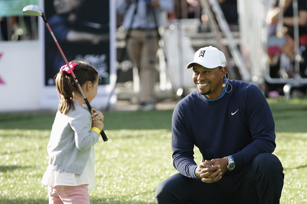 Tiger Woodsda instrucciones a una participante en una clínica de golf para niños y jóvenes en Ciudad de México. (Foto Prensa Libre: EFE)