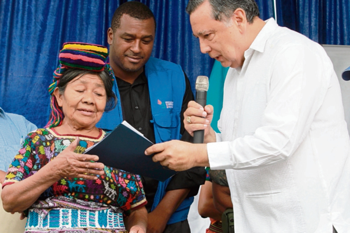 El vicepresidente Alfonso Fuentes entrega el primer cheque a Teodora Chen, sobreviviente de la masacre. (Foto Prensa Libre: Estuardo Paredes)