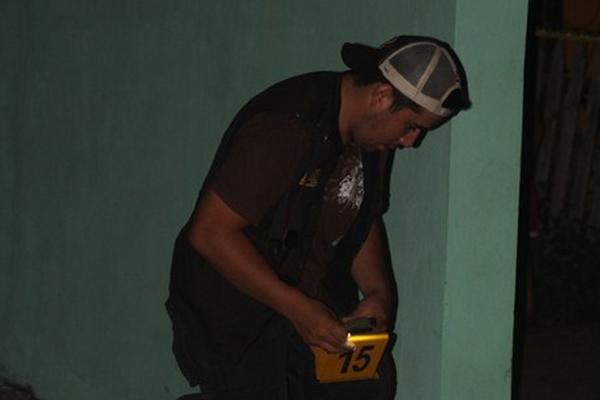 Investigador trabaja en el lugar donde murió baleado Luis Fernando Echeverría, en Puerto Barrios. (Foto Prensa Libre: Edwin Perdomo)