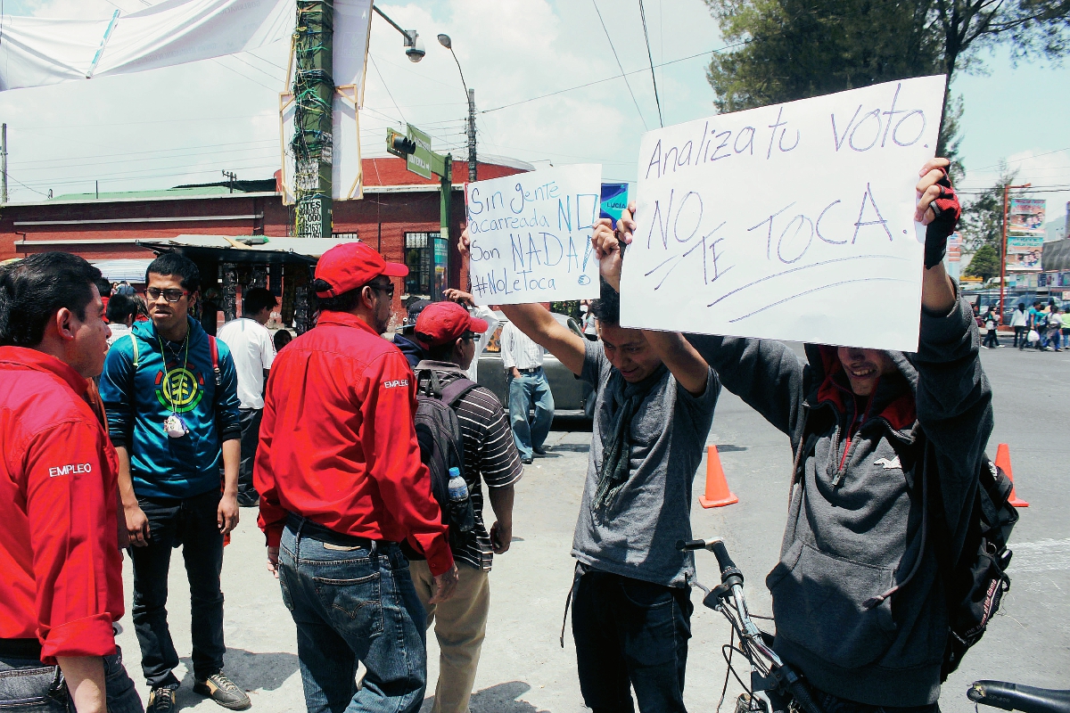 Dos jóvenes piden analizar voto en actividad de Líder, en Quetzaltenango. (Foto Prensa Libre: Carlos Ventura)