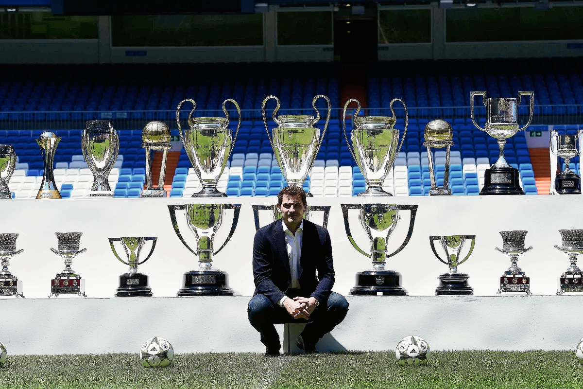 Iker Casillas posa en el estadio Santiago Bernabéu co los trofeos que ganó con el Real Madrid. (Foto Prensa Libre: AFP)