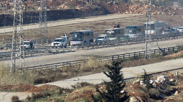 Cuatro autobuses trasladan a personas evacuadas a Ramoussa, en las afueras de Alepo. (Foto Prensa Libre: AFP)