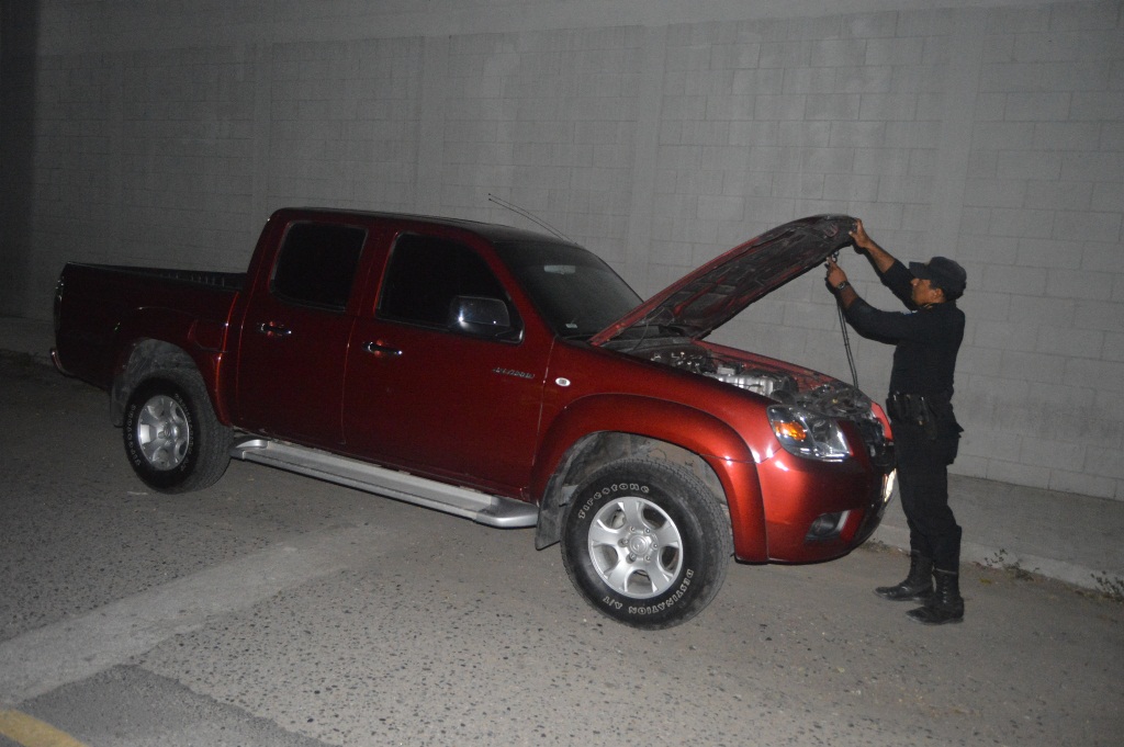 Agente de la PNC inspecciona el automotor que fue recuperado en Teculután, Zacapa. (Foto Prensa Libre: Víctor Gómez)