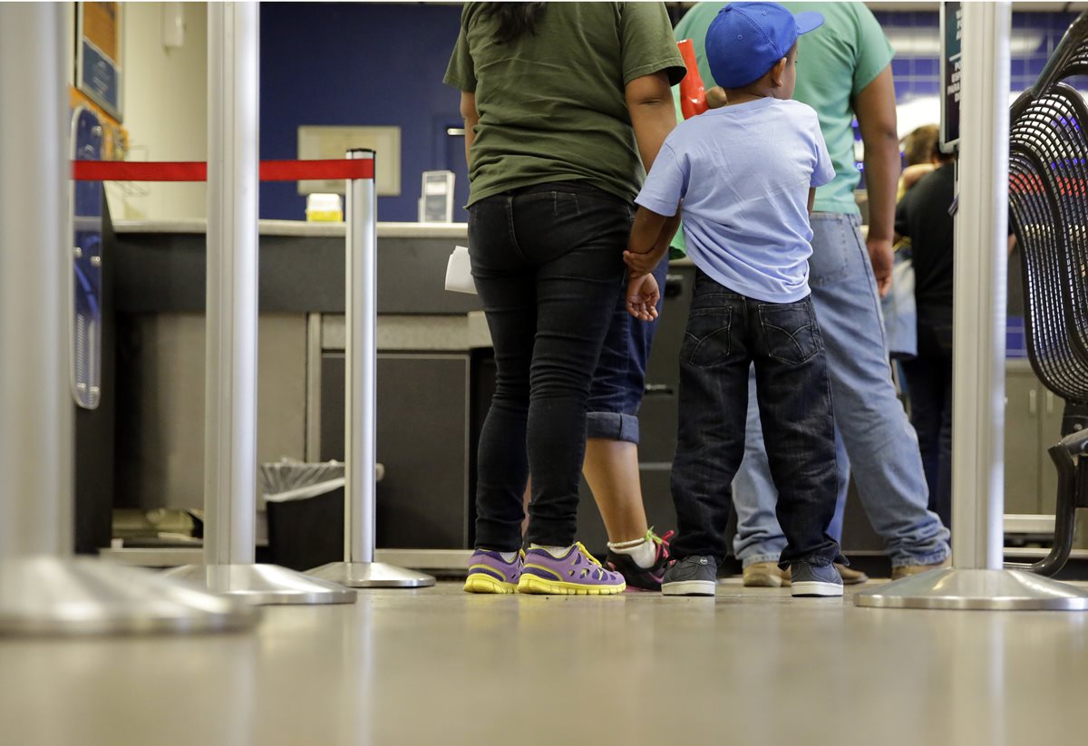Un niño salvadoreño espera junto a sus familiares luego de ser liberados de un centro de detención en EE. UU. (Foto Prensa Libre: AP).