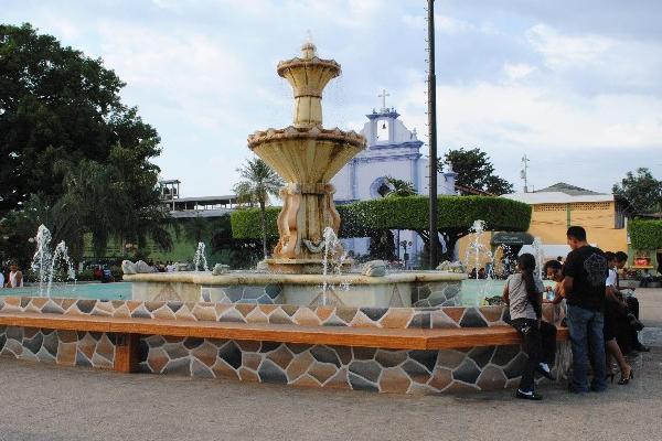 Un grupo  de personas  se refresca   en la fuente del parque central de Tecún Umán, San Marcos.
