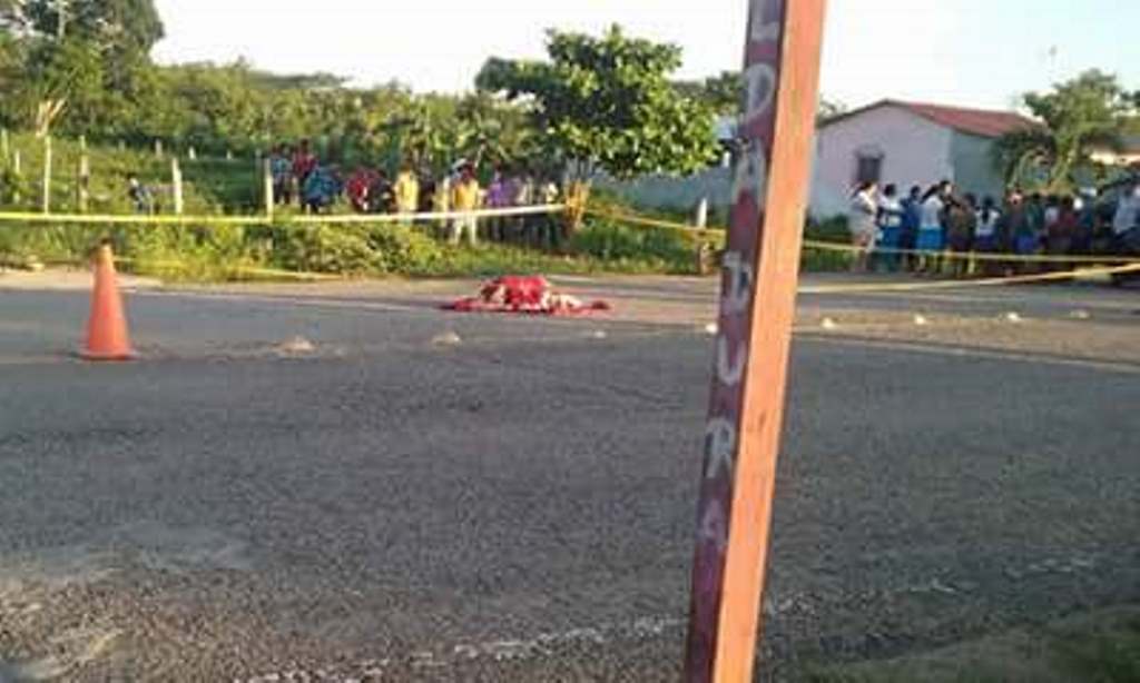 Vecinos observan el cadáver de la maestra Anita Consuelo Guardado Tesucún, en el área conocida como Cruce de El Ceibo, San Andrés. (Foto Prensa Libre: Rigoberto Escobar)