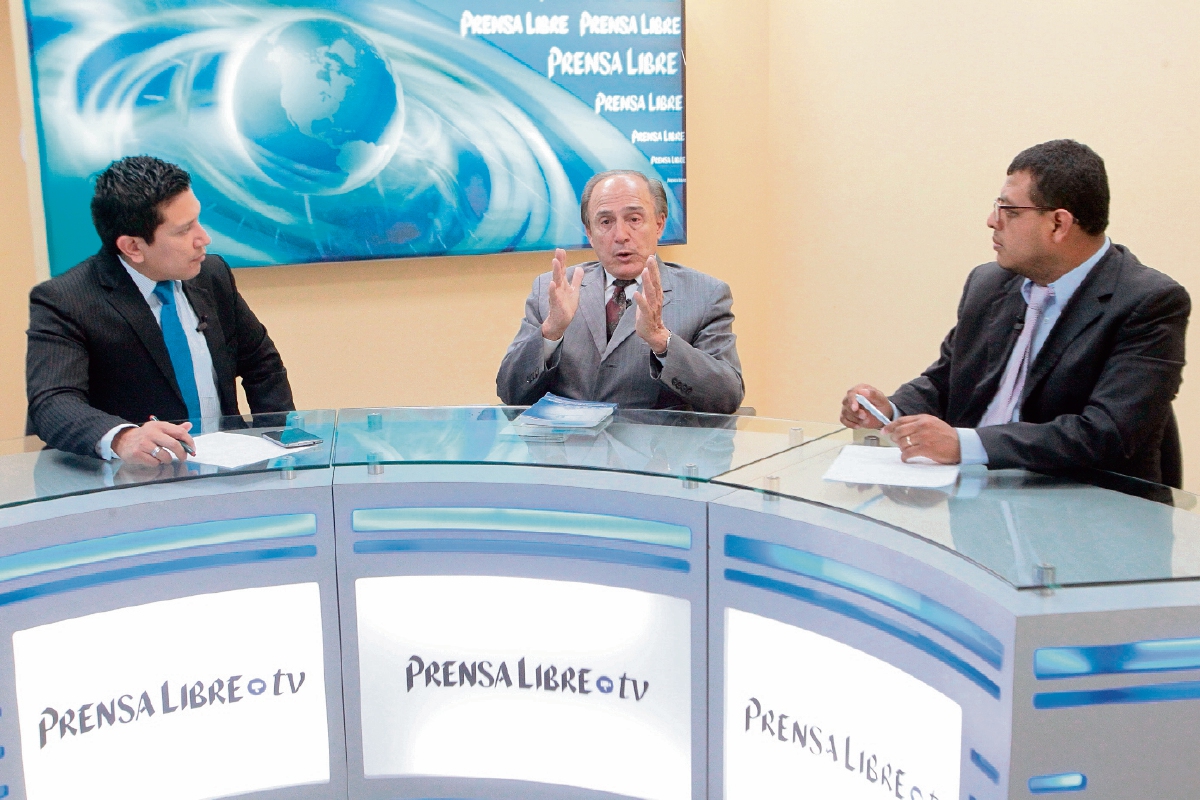 El exmagistrado del TSE Hugo Maúl Figueroa —al centro— conversa con los periodistas Álex Rojas y Manuel Hernández, acerca de los problemas del proceso electoral.