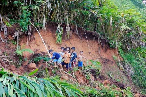 Un grupo de niños camina por un sector donde ocurrió un derrumbe en la aldea Monte Blanco, Purulhá. (Foto Prensa Libre: Carlos Grave)