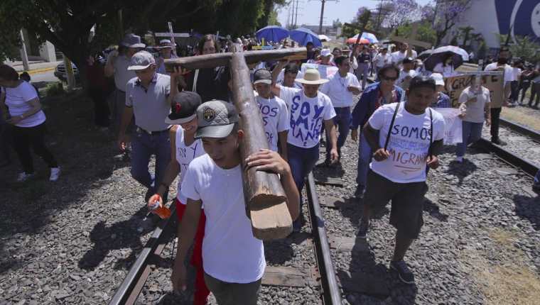 Migrantes participan del singular viacrucis. (Foto Prensa Libre:EFE).