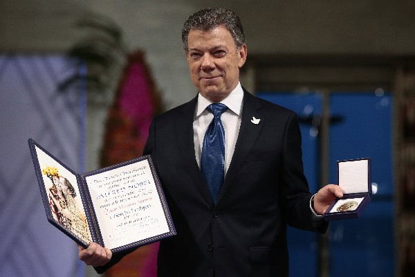 Juan Manuel Santos posa con la medalla y el diploma durante del Premio de la Paz. (Foto Prensa Libre: AFP)