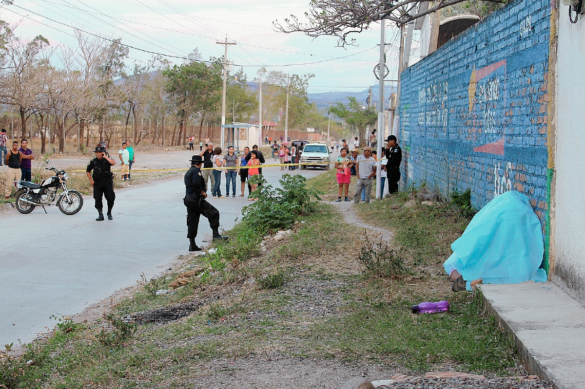 Agentes policiales observan cadáver de trabajadora social Flora Ramírez. (Foto Prensa Libre: Óscar González)