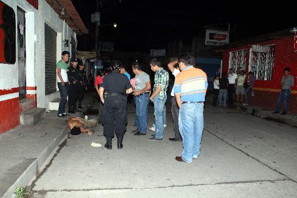 Autoridades y curiosos, junto    al cadáver de un hombre que no fue identificado, en Reu.