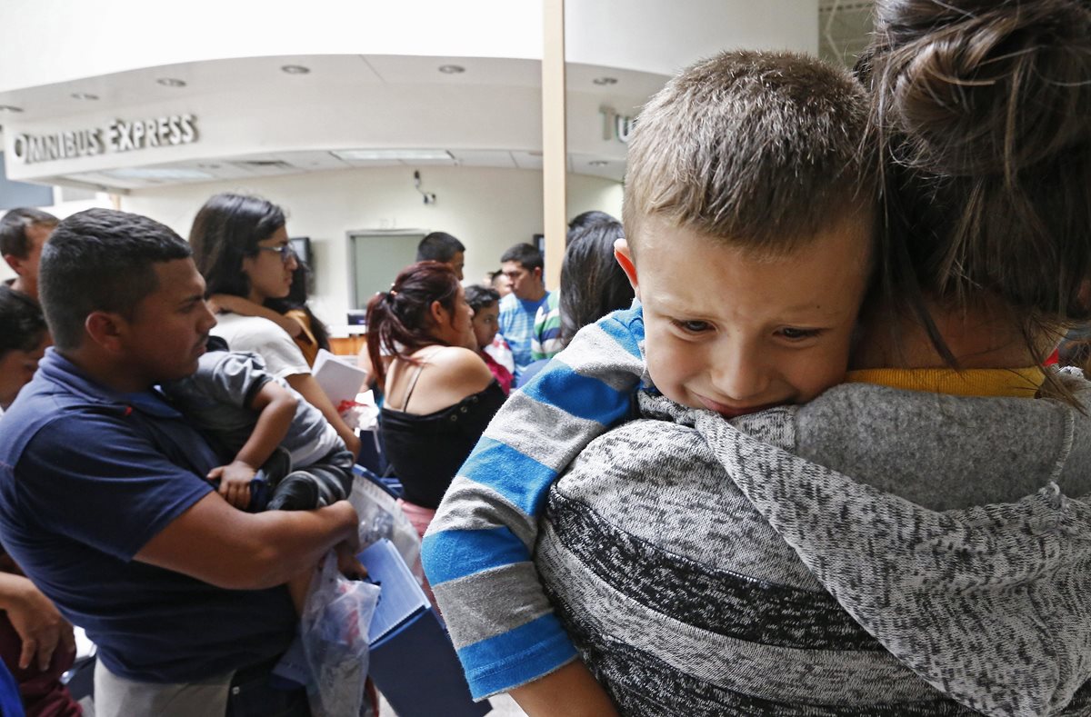 Un niño llora mientras su madre espera a ser procesada en un albergue. (Foto Prensa Libre: EFE)