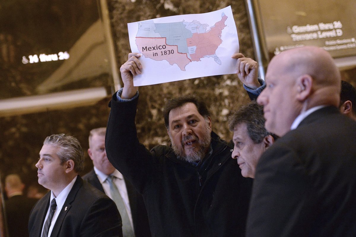 El exdiputado Fernández sostiene un mapa de México y EE. UU., en la Torre Trump de Nueva York, contra los planes migratorios de Trump.(Foto Prensa Libre: EFE).