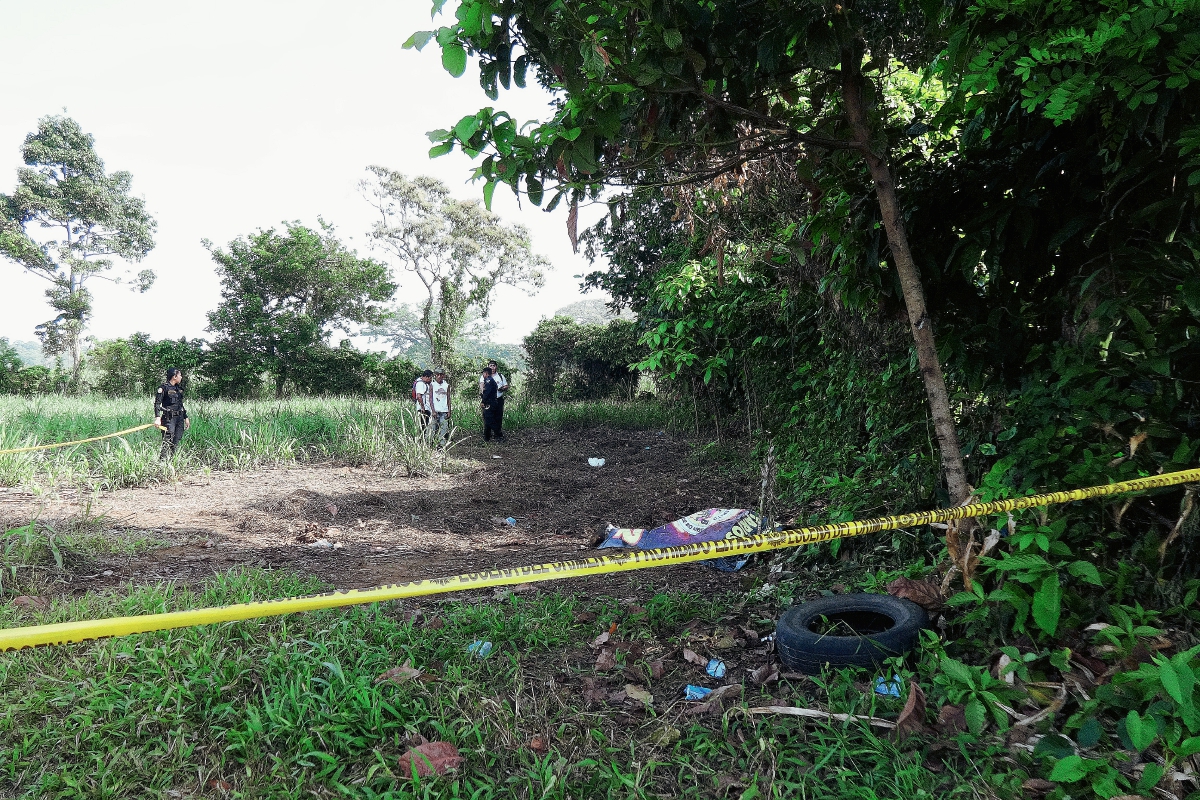 Un agente  de la PNC acordona el área en  donde fue localizado el cadáver de un hombre, en San Antonio Suchitepéquez, Suchitepéquez. (Foto Prensa Libre: Omar Méndez)