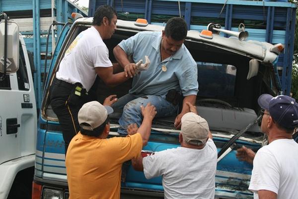 Bomberos Voluntarios rescatan al pilotos que había quedado atrapado en su camión. (Foto Prensa Libre: Edwin Paxtor)<br _mce_bogus="1"/>