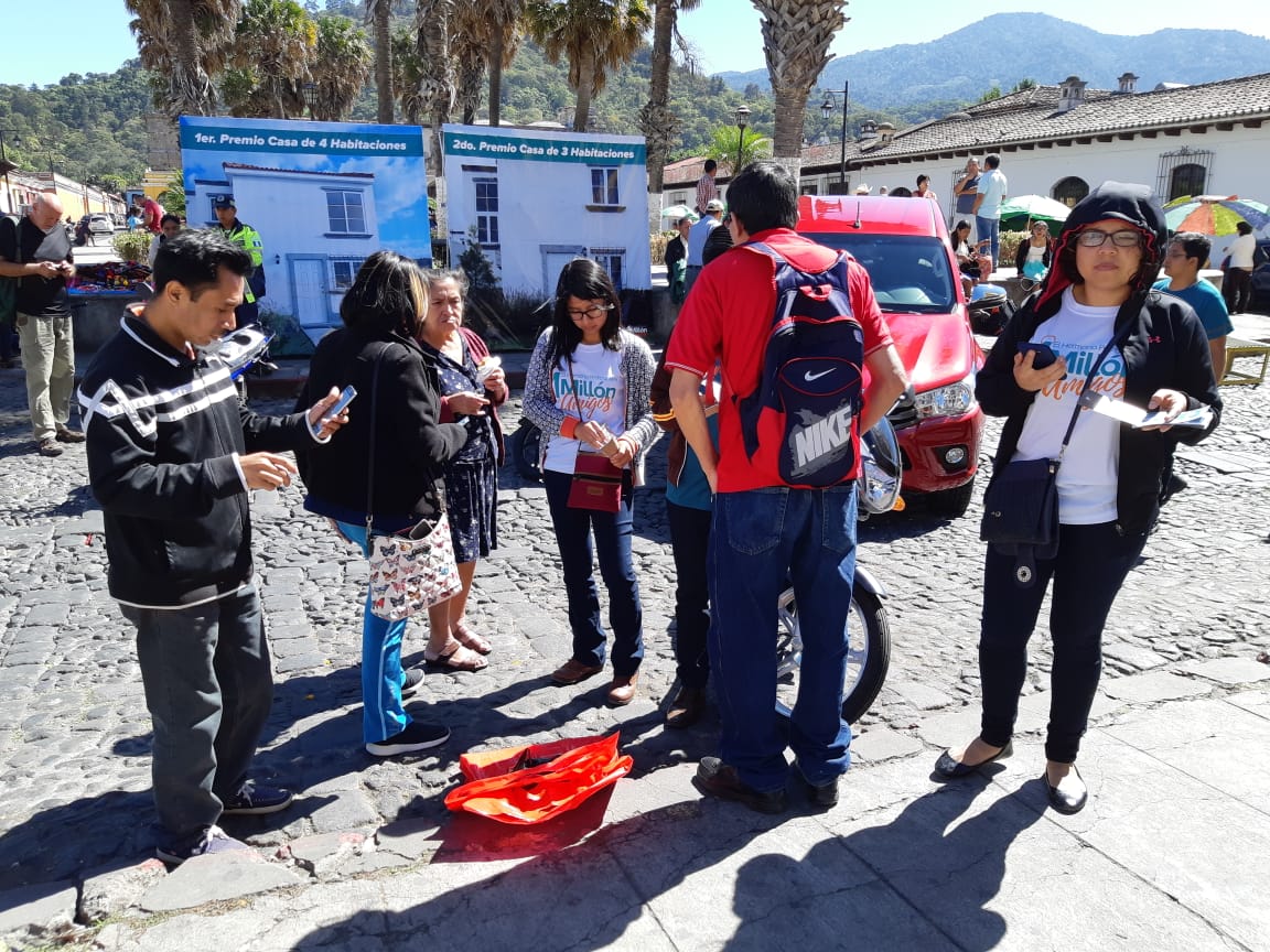 Voluntarios ofrecen los últimos números para la rifa un millón amigos. (Foto Prensa Libre: Julio Sicán)
