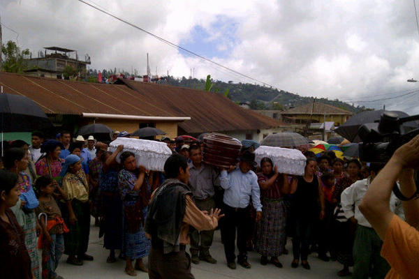 Familia y vecinos acompañan los cuerpos de los tres niños muertos en un  alud, hacia el cementerio. (Foto Prensa Libre: Julio Lara)