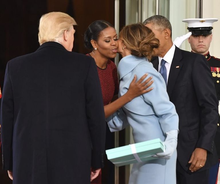 Michelle Obama saluda a Melania Trump en el ingreso a la Casa Blanca, donde la nueva primera dama le entregó un regalo. (Foto Prensa Libre: EFE).