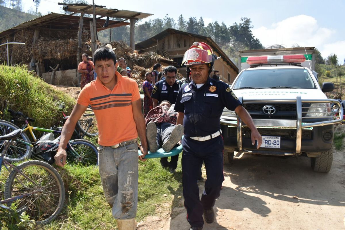 Socorristas trasladan a dos personas que resultaron heridas al caer a un pozo. (Foto Prensa Libre: Víctor Chamalé)