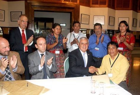 El presidente Otto Pérez Molina junto a representantes de las 33 comunidades y testigos de honor, durante la firma del acuerdo de resarcimiento (Foto Prensa Libre: Presidencia)