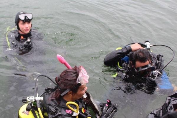 La vicepresidenta Roxana Baldetti, auxiliada por buzos, se sumerge en el lago Petén Itzá, del cual personal militar extrajo varias botellas, entre otro tipo de desechos —foto inserta—.