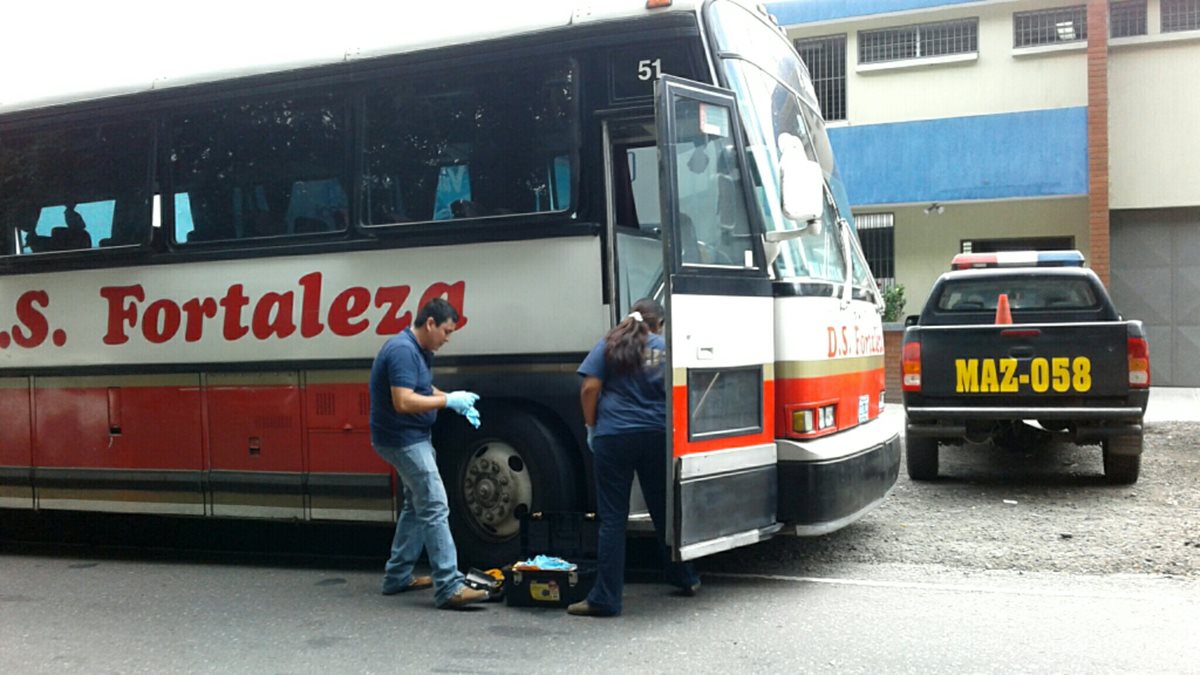 Peritos del MP recogen evidencia en el autobús donde ocurrió la balacera. (Foto Prensa Libre: Melvin Popá)