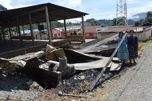 Feliciana Pacay -blusa celeste- y Elizet Us muestran una de las vigas quemadas del comedor, en Uspantán. (Foto Prensa Libre: Óscar Figueroa)