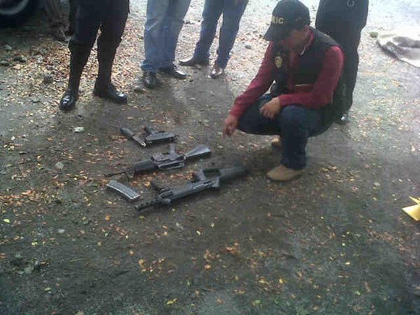 Agentes policiales resguardan armamento localizado en Puerto San José, Escuintla. (Foto Prensa Libre: PNC)