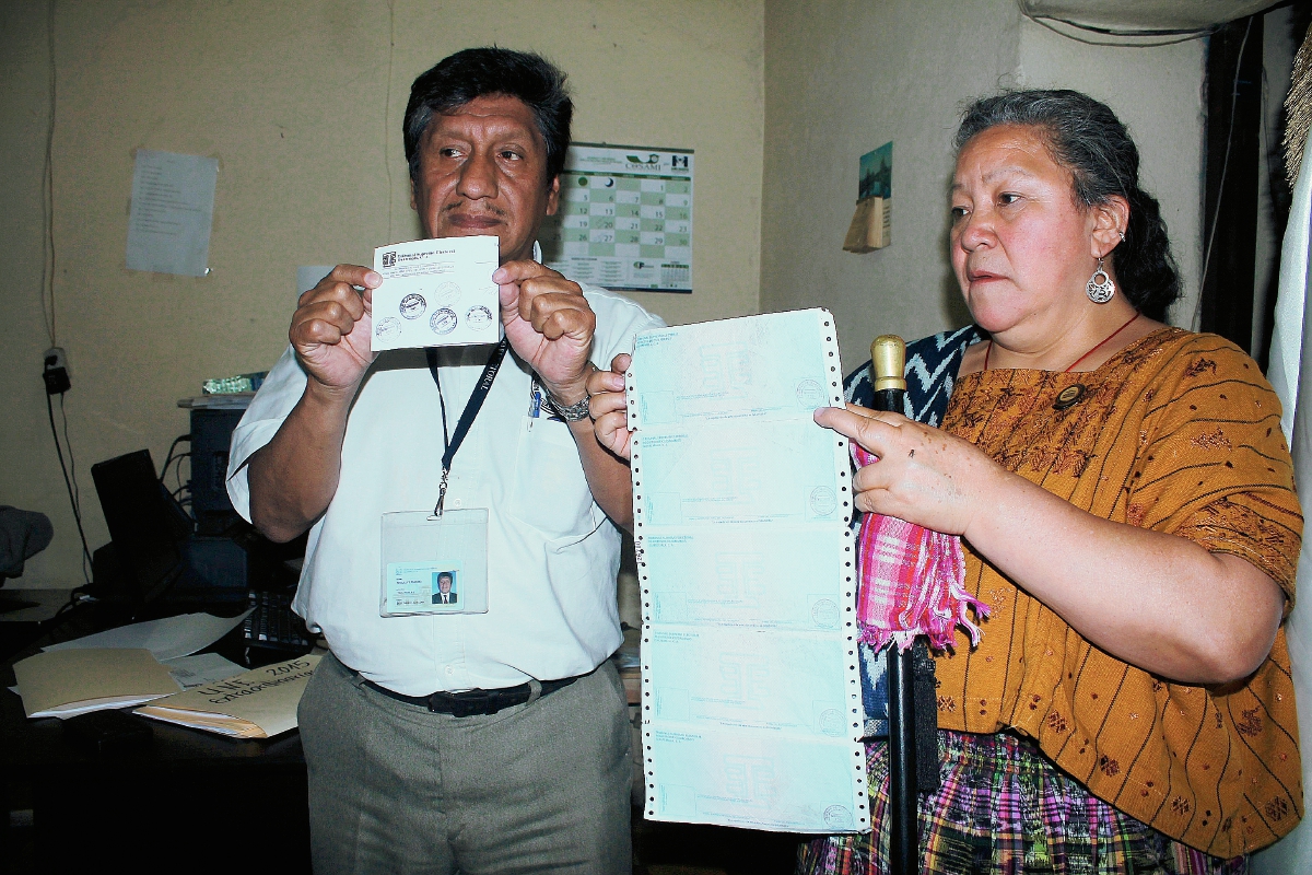 Autoridades muestran algunas de las boletas encontradas. (Foto Prensa Libre: Édgar Domínguez)
