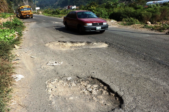 Pilotos que utilizan la ruta de Retalhuleu a Quetzaltenango deben esquivar la gran cantidad de hoyos que hay en carretera, lo que ha causado accidentes. Alrededor de 100 personas han muerto desde el 2005, según cuerpos de socorro. (Foto Prensa Libre: Carlos Ventura)