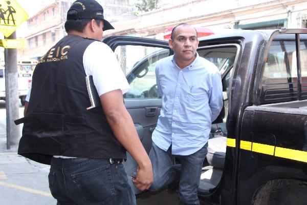 El empresario salvadoreño Raúl Antonio Reyes Aguilar, sindicado de retención indebida y estafa propia, baja de un autopatrulla para comparecer ante el juez que conoce su caso.