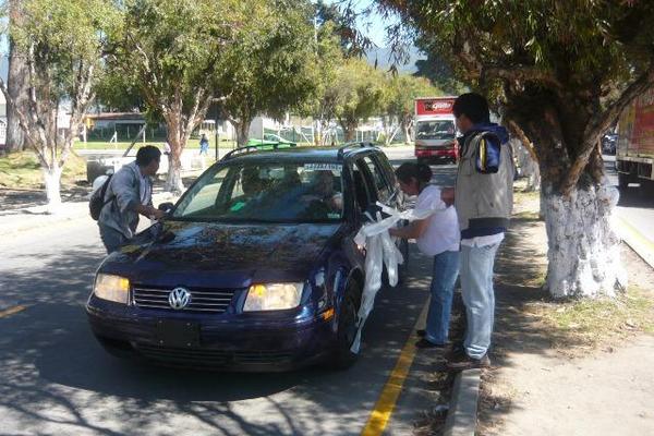 Dos jóvenes colocan cintas blancas en un vehículo durante la caminata por la vida y la paz realizada en San Marcos. (Foto Prensa Libre: Genner Guzmán)  <br _mce_bogus="1"/>