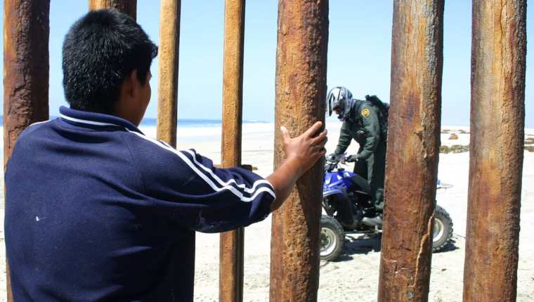Un inmigrante mira desde México a un oficial de la patrulla fronteriza de EE. UU. (Foto Prensa Libre: Hemeroteca PL)
