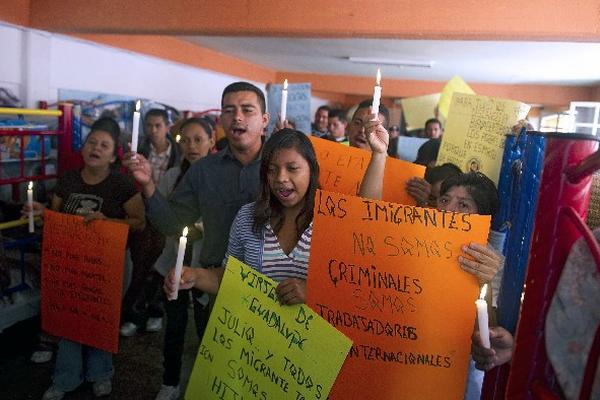 Migrantes encienden velas frente a la Casa del Migrante San Juan Diego, México, por Julio Cardona —foto inserta—.