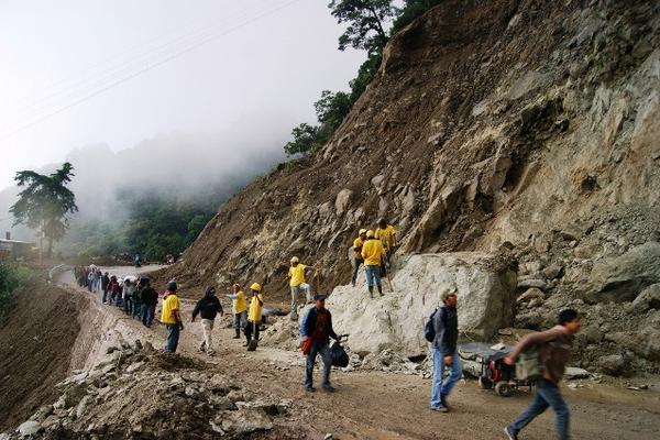 Pobladores pasan a pie por el sector de La Catarata, mientras una cuadrilla de Covial intenta quebrar las rocas que caen, para habilitar el paso. (Édgar Sáenz)<br _mce_bogus="1"/>