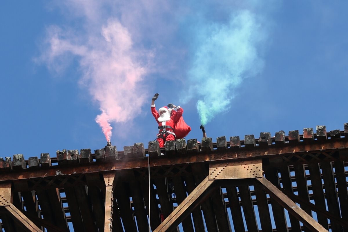 El Santa Claus bombero desciende del puente Las Vacas con una bolsa llena de regalos para niños de las colonias bajo el puente Belice. (Foto Prensa Libre: Esbin García)